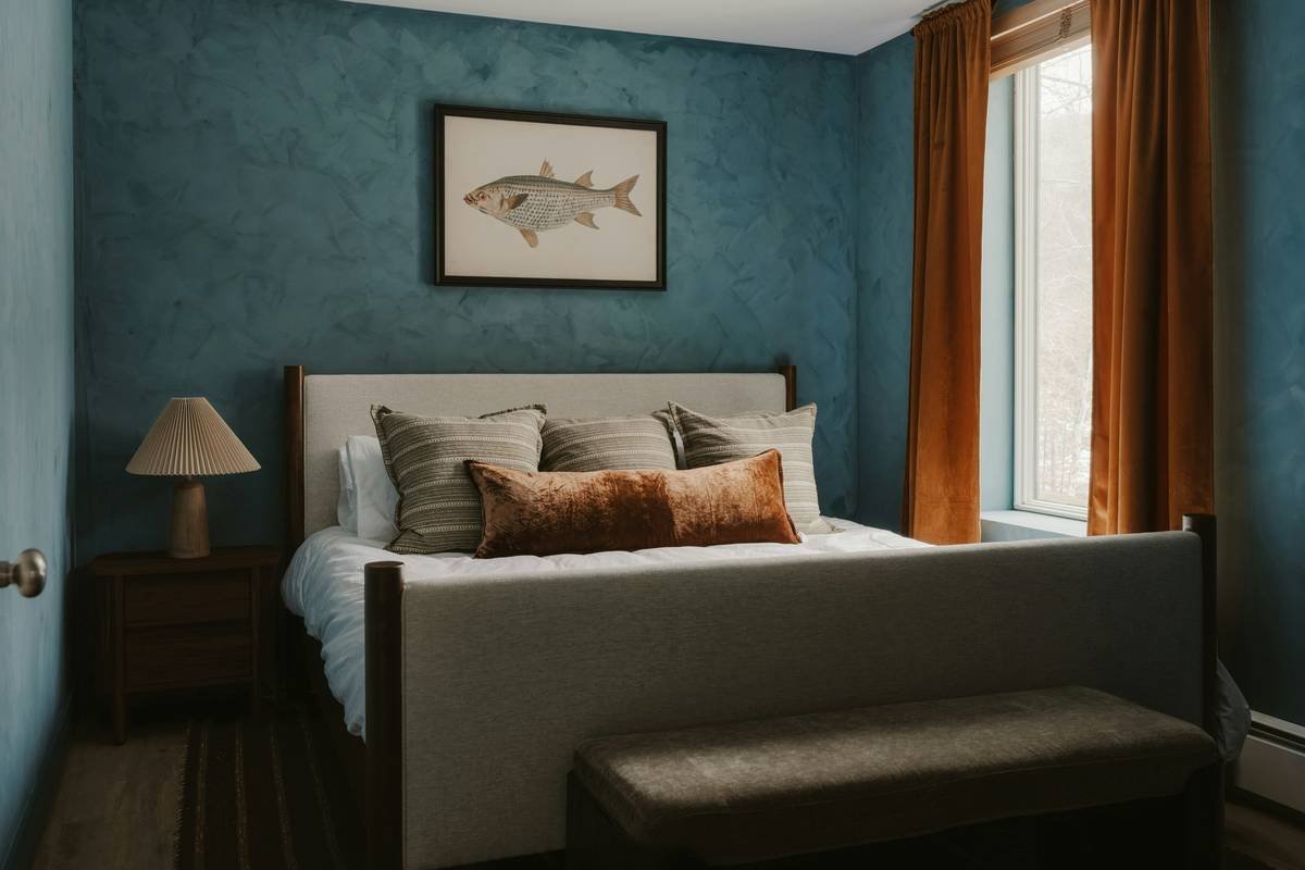 Mood board showing authentic coastal bedroom elements: whitewashed wood nightstand, linen curtains, jute rug, and neutral wall tones