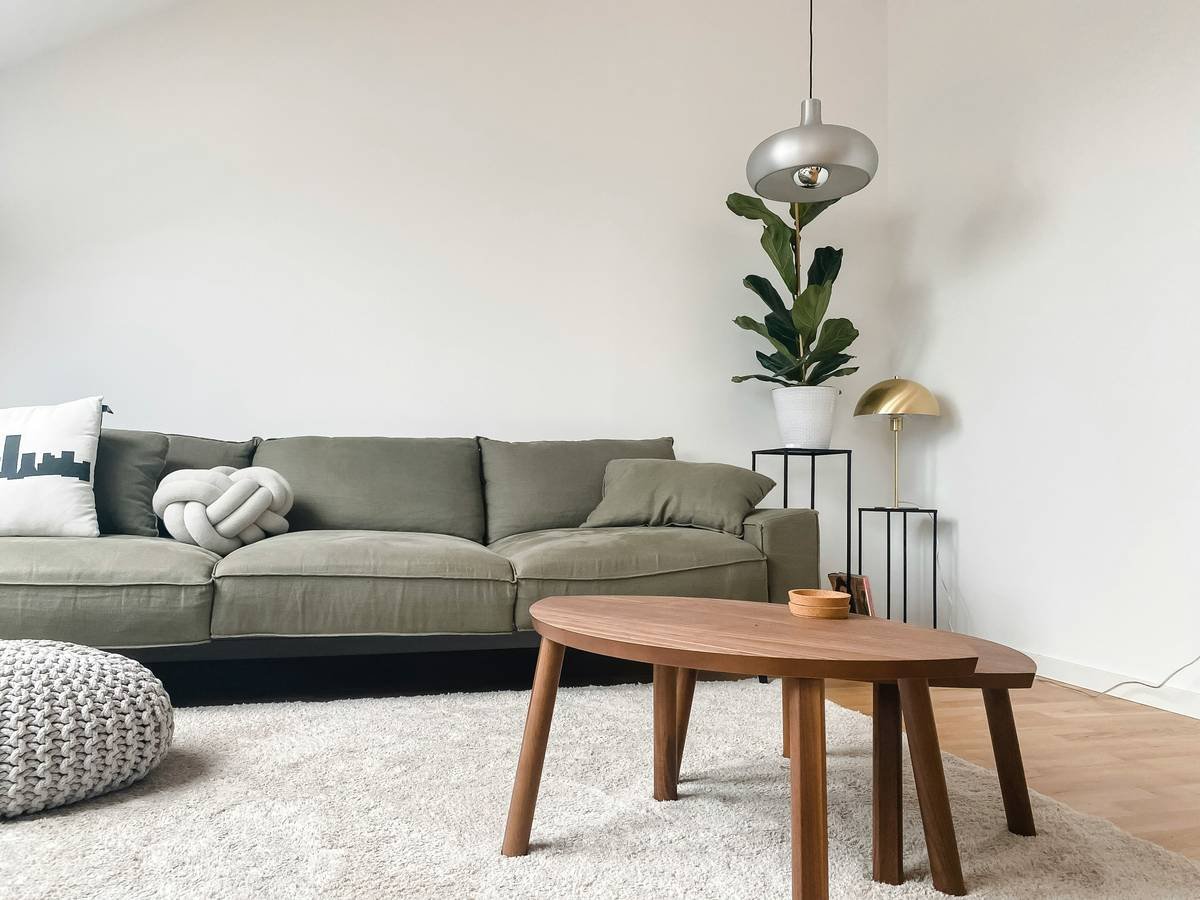 Rustic coastal living room setup featuring teak coffee table and Sunbrella fabric sofa in summer home coastal vacation used rental