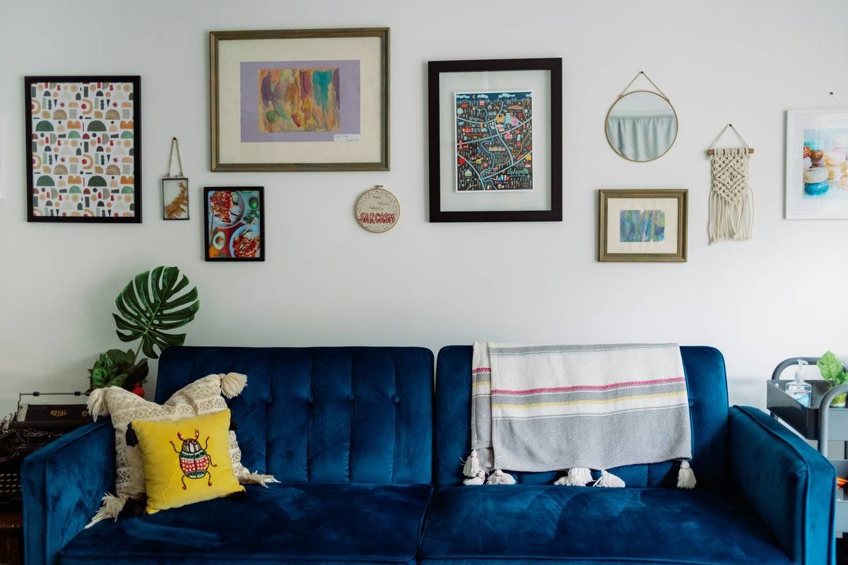 nautical style coastal navy blue sofa in a bright seaside living room with jute rug and driftwood side table